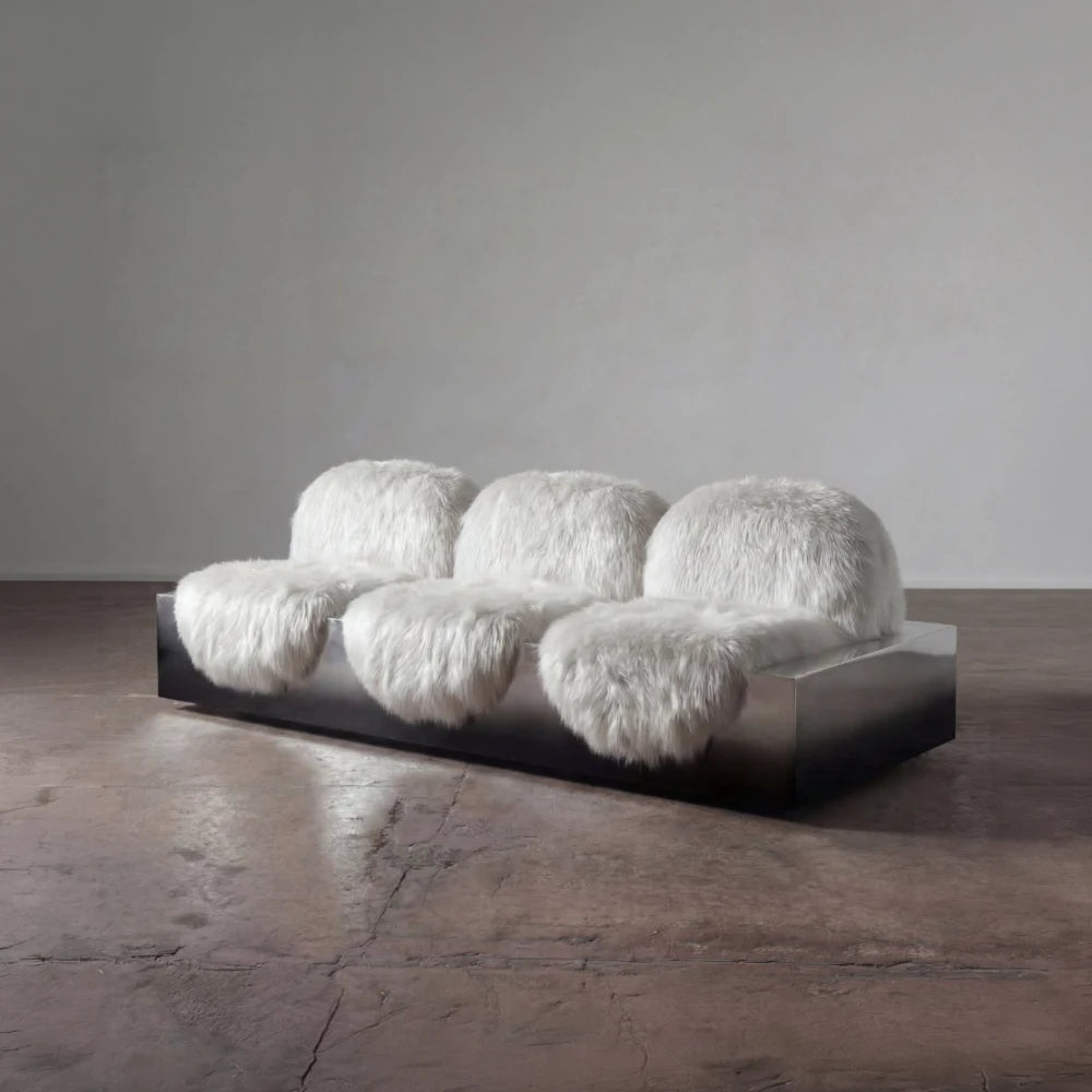 Three-quarter view of the Sans Poids sofa by Diamant Versatile, featuring three white long-haired upholstered seats on a metal base.